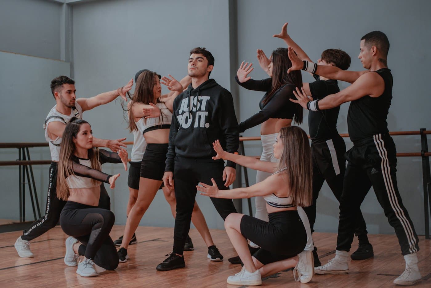 A dance teacher leading a class of students in a studio